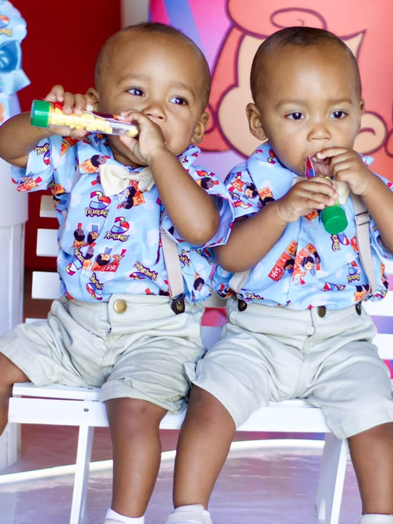 Gêmeos sentados no banquinho da festa de aniversário infantil