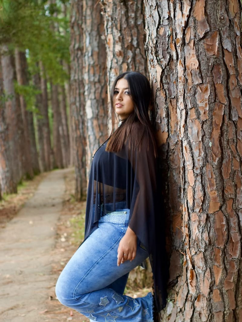 Ensaio individual de mulher encostada em um pinheiro no bosque