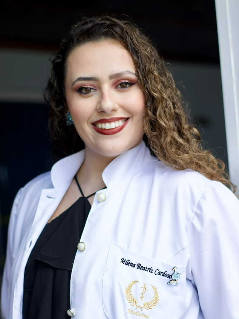 Estudante de medicina sorrindo com o jaleco bordado
